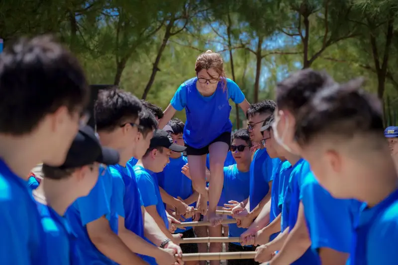 BSS team members in blue shirts playing an outdoor team-building game together