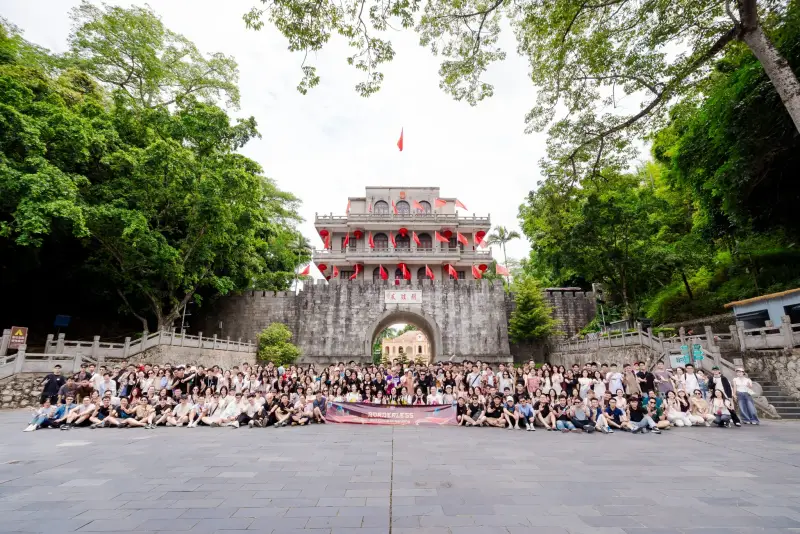 A wide group photo of the BSS Group team in front of a historic stone gate, with a Borderless banner at the front